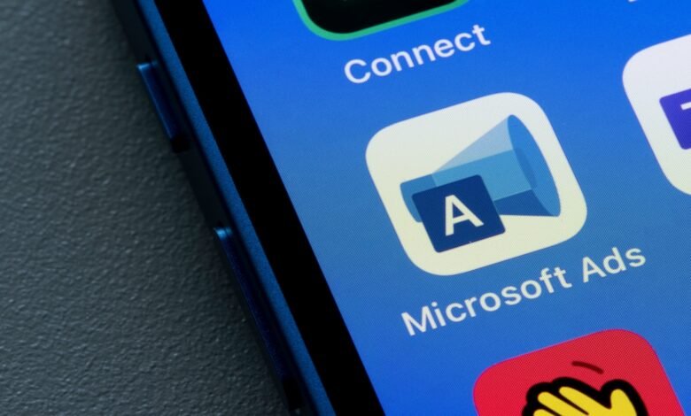 Microsoft Ads app icon on a blue smartphone screen.