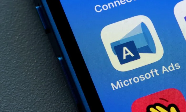 Microsoft Ads app icon on a blue smartphone screen.
