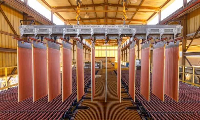 Copper electrorefining process with large copper sheets suspended in a factory setting.