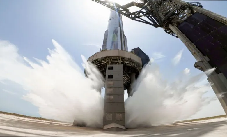 Rocket launch pad undergoing water deluge test, water spraying from structure.