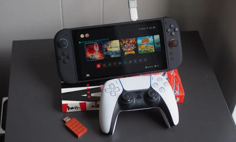 Nintendo Switch with games and a PlayStation 5 controller on a table.