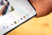 Close-up of a foldable phone displaying a taskbar with app icons.