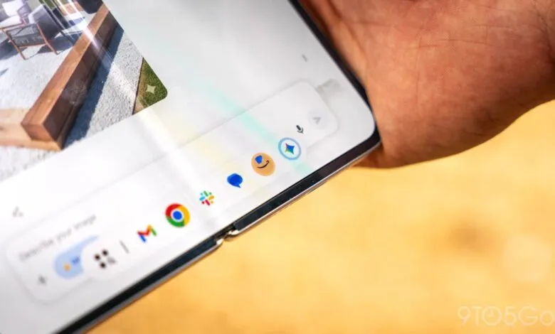 Close-up of a foldable phone displaying a taskbar with app icons.