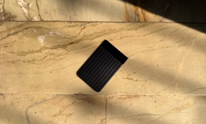 Black Plaud Note Pro device on marble surface with sunlight.