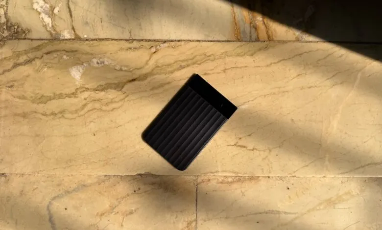Black Plaud Note Pro device on marble surface with sunlight.