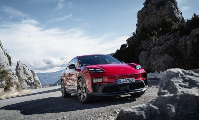 Red Porsche Taycan Cross Turismo driving on a scenic mountain road.