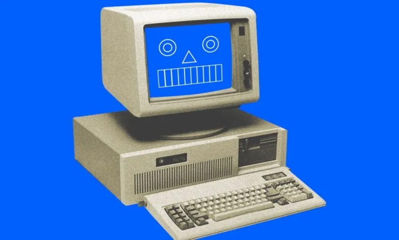 Vintage computer with a blue screen displaying a simple face.