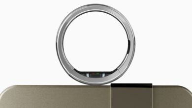 Ultrahuman Ring Pro on charging dock, silver and gold tones.