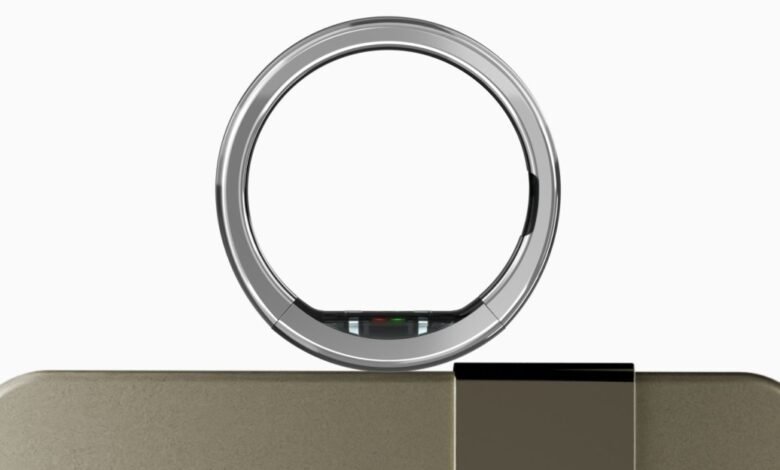 Ultrahuman Ring Pro on charging dock, silver and gold tones.