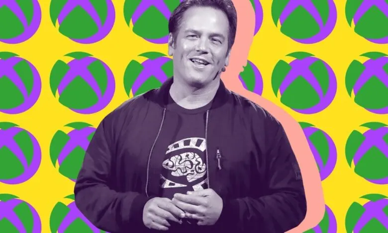 Phil Spencer, head of Xbox, smiles against a vibrant Xbox-themed background.