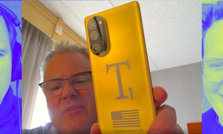 Man holding gold 'Trump Mobile' phone with American flag design.