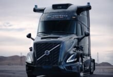 Front view of a black Volvo VNL autonomous truck with sensors on top.