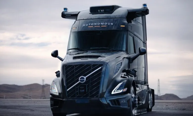 Front view of a black Volvo VNL autonomous truck with sensors on top.