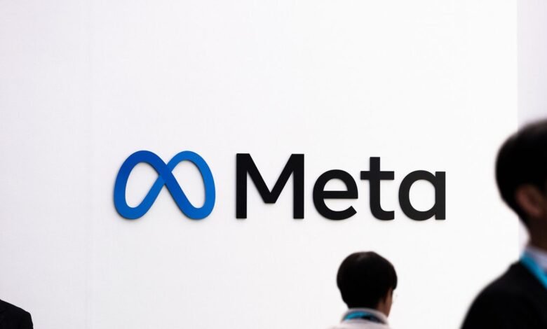 Meta logo on a white wall with people passing by.