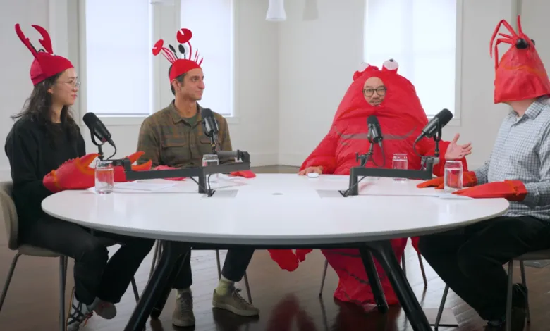 Four people in crab costumes sit at a round table with microphones.