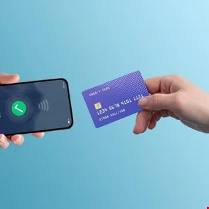 Person holds credit card near smartphone displaying contactless payment confirmation.