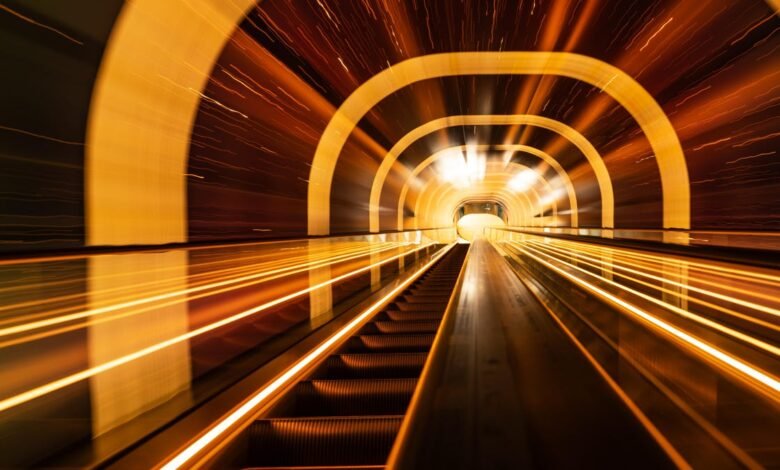 Abstract view of escalator tunnel with blurred golden lights.