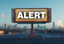 Billboard with the word 'ALERT' against a city skyline.