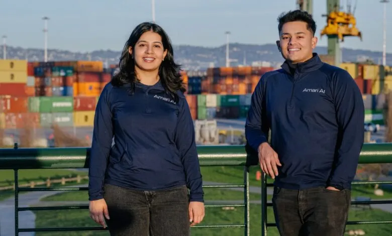 Two Amari AI team members stand outdoors with shipping containers in the background.