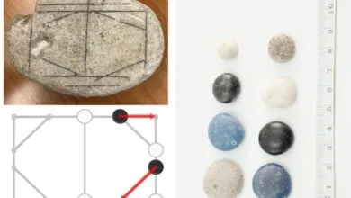 Ancient Roman game board etched on stone with playing pieces.