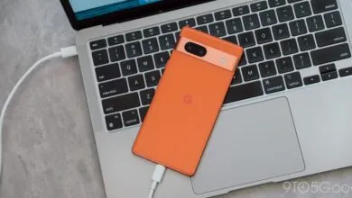 Orange Google Pixel phone charging on a silver MacBook keyboard.