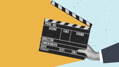 Film slate held by hand against a colorful background, ready for action.