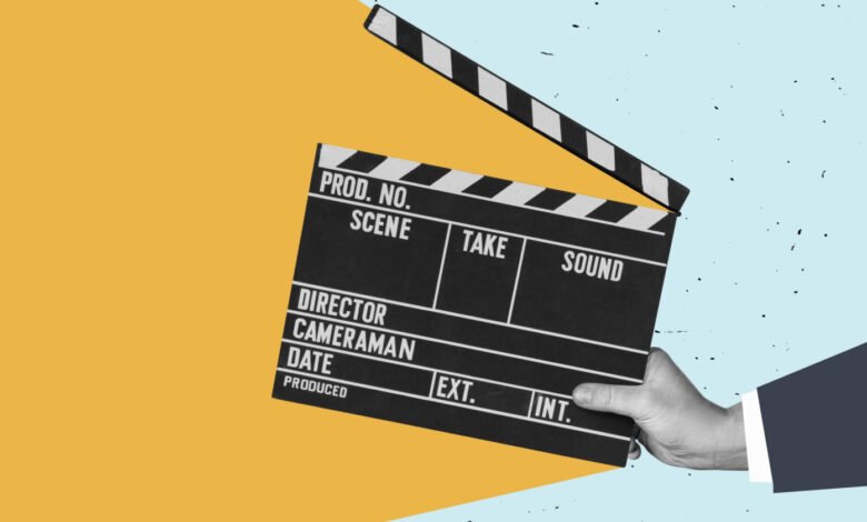 Film slate held by hand against a colorful background, ready for action.