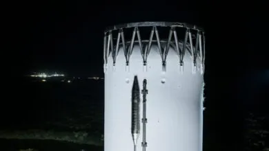 Starship prototype at night, showing its white exterior and metal framework.