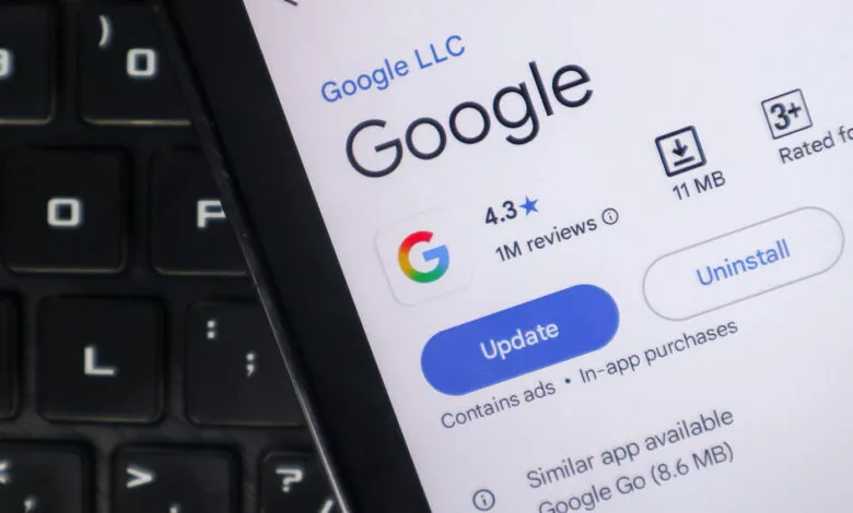 Google app listing on a phone screen with a laptop keyboard in the background.