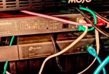 Network rack with TP-Link Omada switch and controller, plus colorful ethernet cables.