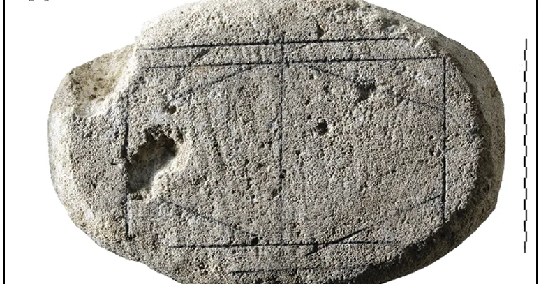 Stone artifact with geometric design etched on its surface.