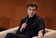 Brian Chesky, Airbnb CEO, speaking into a microphone while seated.