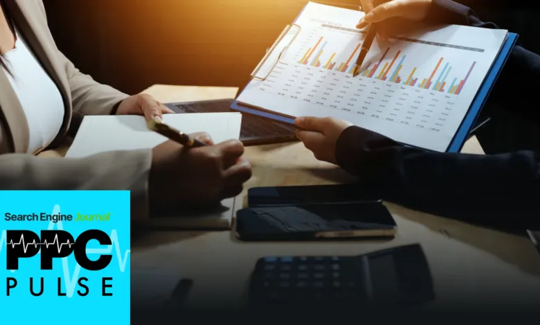 Two people review expense trends chart, taking notes at a desk.