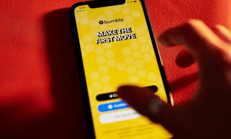 Bumble dating app displayed on a smartphone with a hand touching the screen.