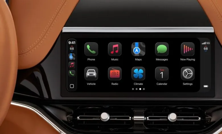 Car dashboard display showing Apple CarPlay interface with various app icons.