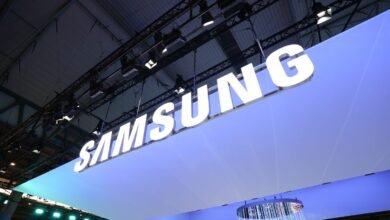 Illuminated Samsung logo suspended from a convention center ceiling.