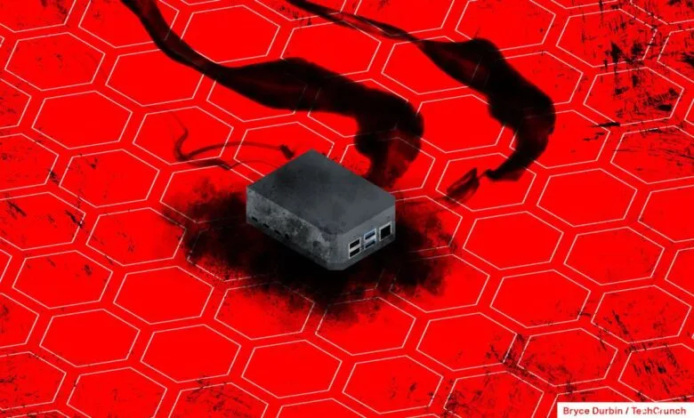 Small gray computer on red honeycomb background with dark, smoky tendrils.