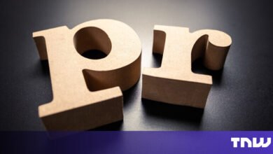 Wooden letters 'PR' on a dark surface, close-up shot.