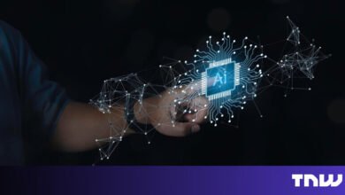 Hand holding glowing AI chip with network connections in dark space.