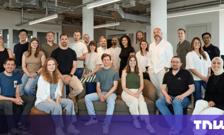 Diverse team of professionals posing for a group photo in a modern office.
