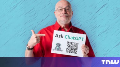 Man holds 'Ask ChatGPT' sign with QR code, pointing at it.