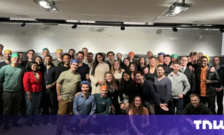 Large group of diverse people wearing party hats, celebrating together.