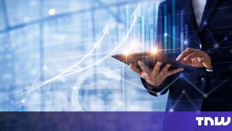 Person in suit using tablet with financial data overlay.