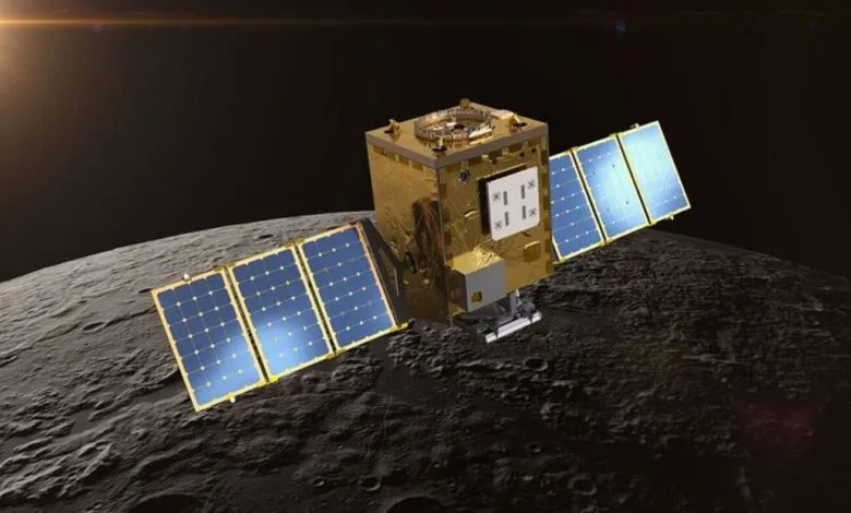 Satellite orbits the moon, solar panels extended, against a dark space background.