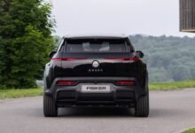 Rear view of a black Fisker Ocean electric SUV on a paved road.