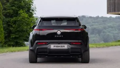 Rear view of a black Fisker Ocean electric SUV on a paved road.