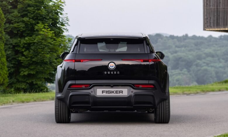 Rear view of a black Fisker Ocean electric SUV on a paved road.
