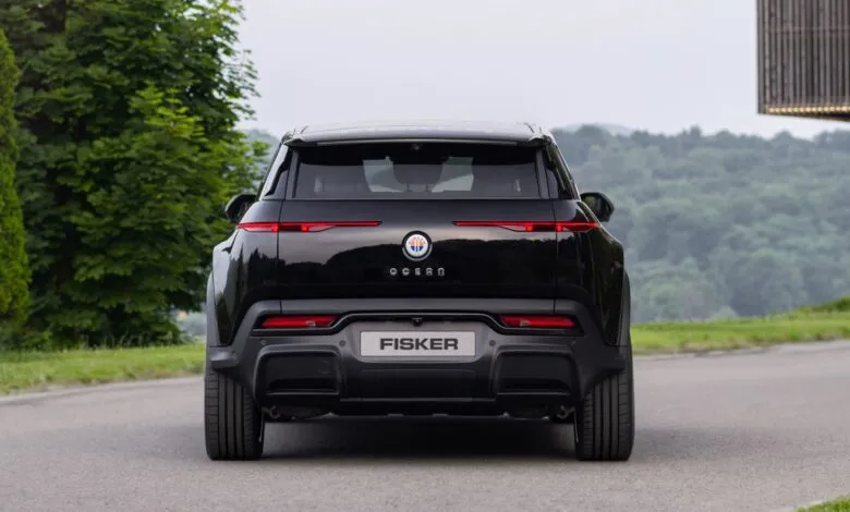 Rear view of a black Fisker Ocean electric SUV on a paved road.