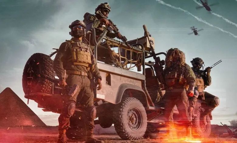 Four armed soldiers on a vehicle in desert with pyramids in background.