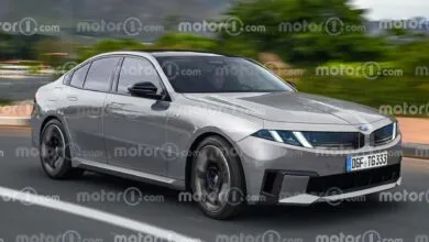 Silver BMW 3 Series Neue Klasse concept car driving on a road.